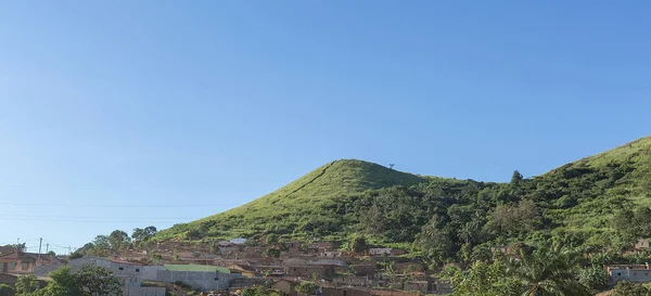 Pueblo rural en Angola, casas en la colina, lleno de vegetación . — Foto de Stock
