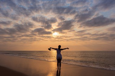 Kollarını açarak, sunset ve dramati genç kızla silüeti