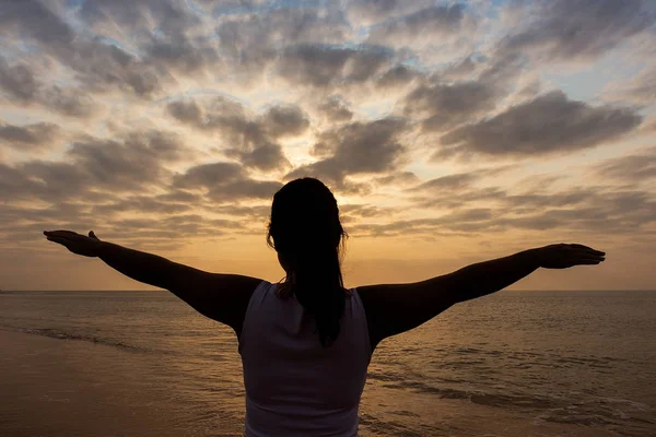 Kollarını açarak, sunset ve dramati genç kızla silüeti
