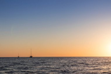 Güzel gün batımı denizden gördün. İki Katamaran ile Santorini