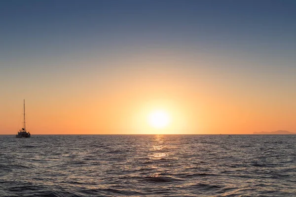 Güzel gün batımı denizden gördün. Bir katamaran ile Santorini