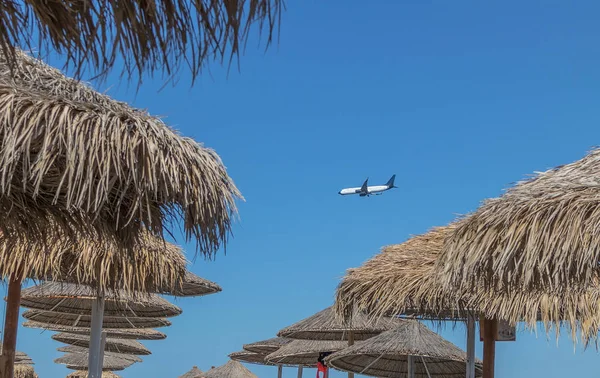 Airplane landing at santorini airport seen from Kamari beach. Wi