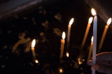 Kilisede mum koyarak kadın el.