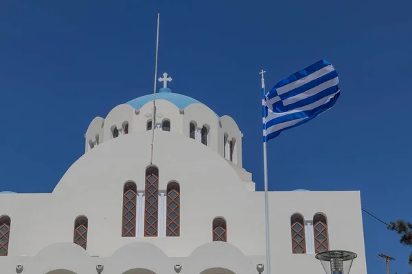 Греческая церковь Санторини с греческим флагом . — стоковое фото
