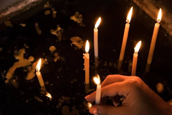 Mulher mão colocando vela na igreja . — Fotografia de Stock