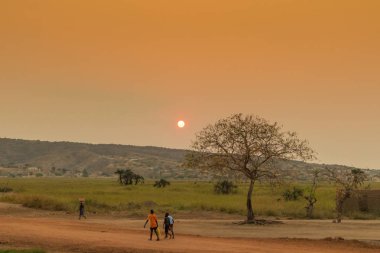 İş, gün batımı ile dönen Afrika kırsal insanlar. Sumbe. Bir