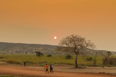 African rural people returning from work, with sunset. Sumbe. An clipart