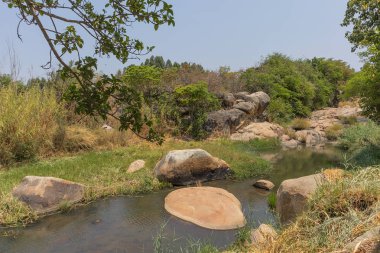 akıcı nehir kayalar ve Afrika'da bitki örtüsü. Lubango. İngiliz