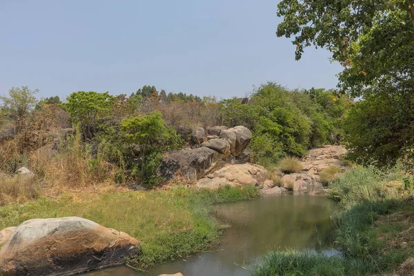 akıcı nehir kayalar ve Afrika'da bitki örtüsü. Lubango. İngiliz