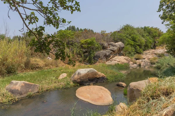 akıcı nehir kayalar ve Afrika'da bitki örtüsü. Lubango. İngiliz