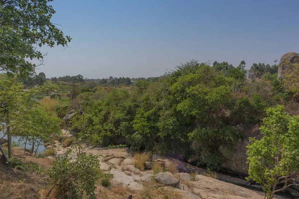 akıcı nehir kayalar ve Afrika'da bitki örtüsü. Lubango. İngiliz