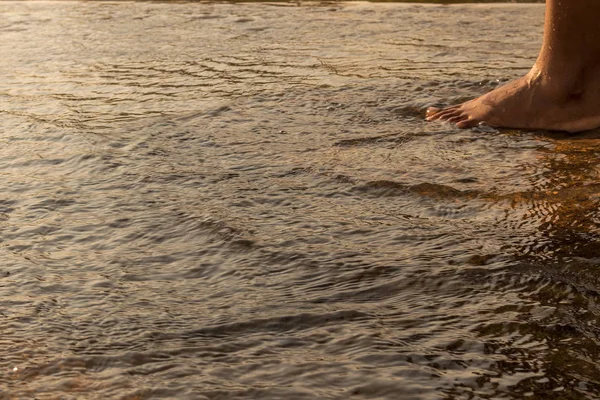Gün batımı lig ile su üzerinde yürümek için Afrika genç kızın bacakları