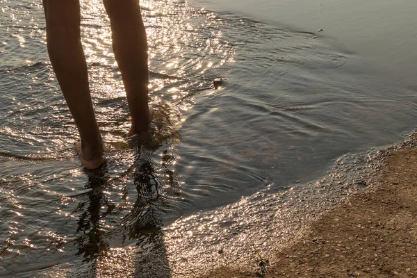Африканская девушка ноги ходить по воде с крышкой заката — стоковое фото