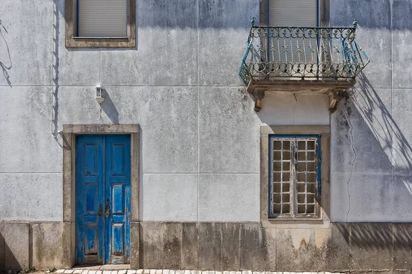 Фасад старого португальского дома с голубой дверью . — стоковое фото