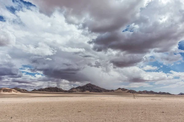Panorama minimaliste du désert namibien avec montagnes et ciel nuageux . — Photo