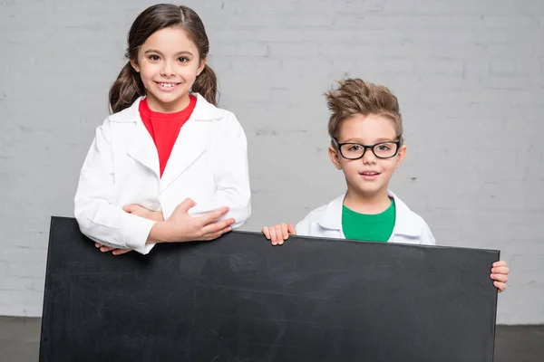 Niños sosteniendo pizarra —  Fotos de Stock