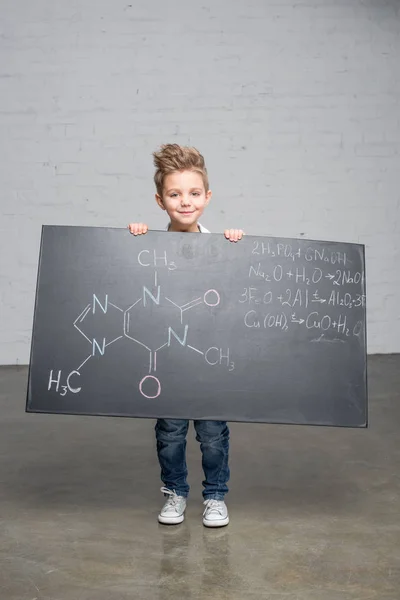 Pojke anläggning blackboard — Stockfoto