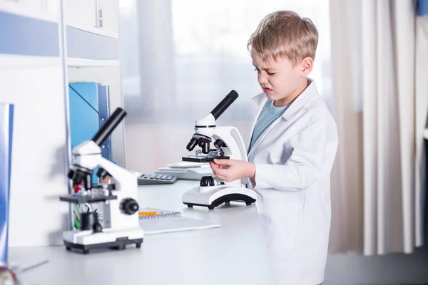 Menino usando microscópio — Fotografia de Stock