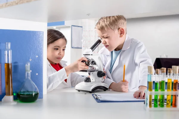 Niños usando microscopio — Foto de Stock