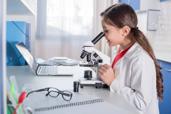 Menina usando microscópio — Fotografia de Stock