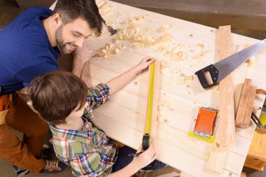 Father and son in workshop clipart