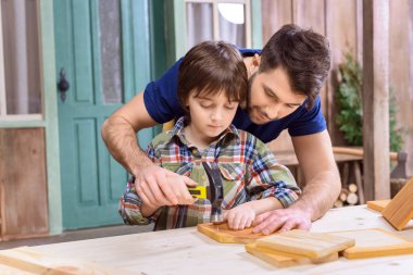 Father and son in workshop  clipart