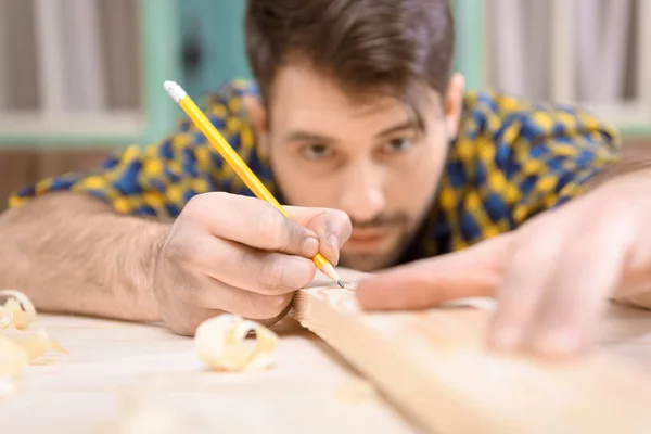 Carpenter measuring plank — Stock Photo, Image