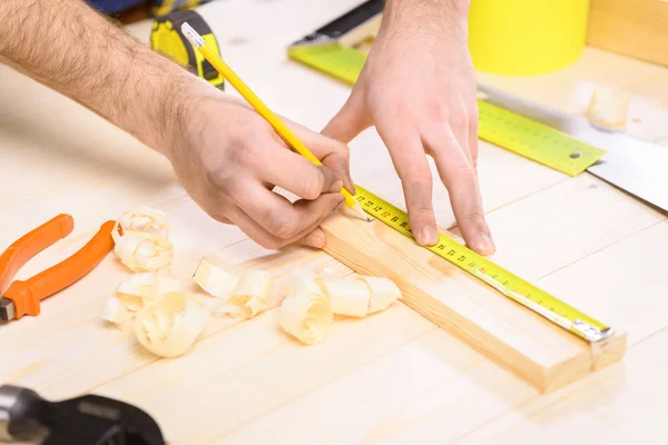 Carpenter measuring plank — Stock Photo, Image