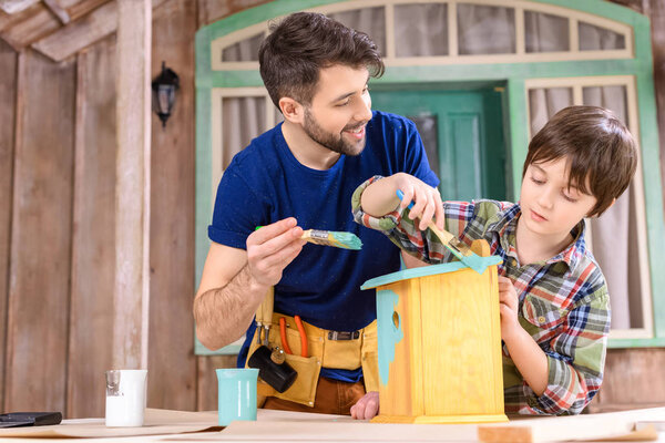Father and son making birdhouse