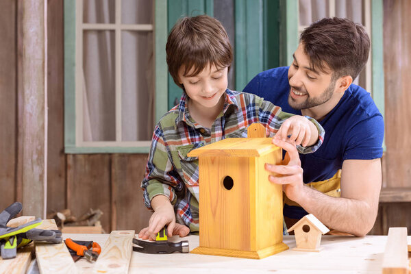 Father and son making birdhouse 