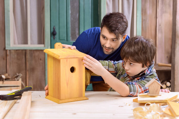 Father and son making birdhouse 