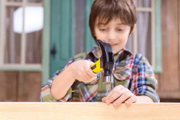 Boy hammering nail — Stock Photo, Image