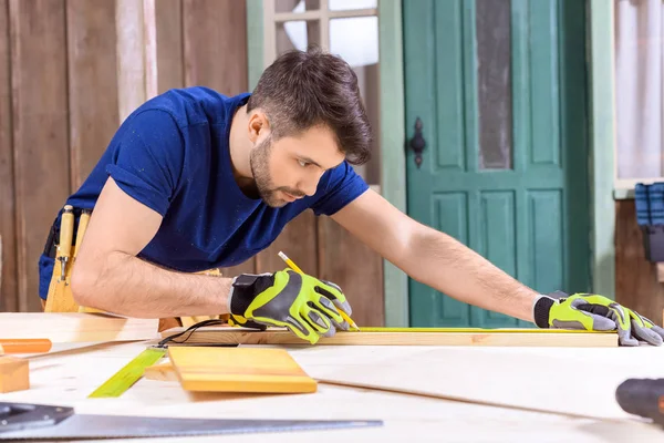 Carpenter working with wooden plank — Stock Photo, Image