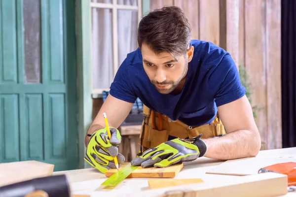 Carpenter working with wooden plank — Stock Photo, Image