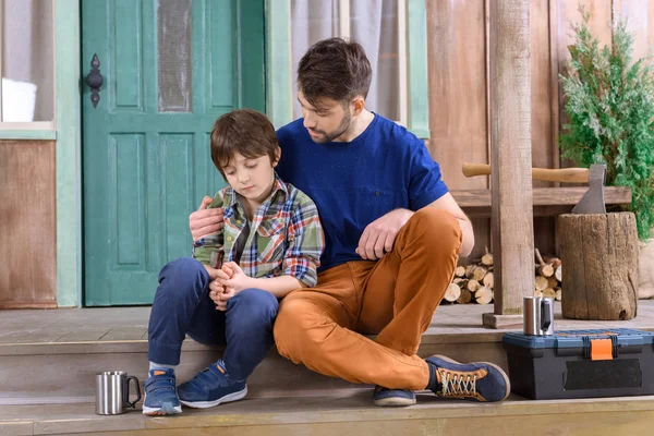 Man and boy sitting on porch — Stock Photo, Image