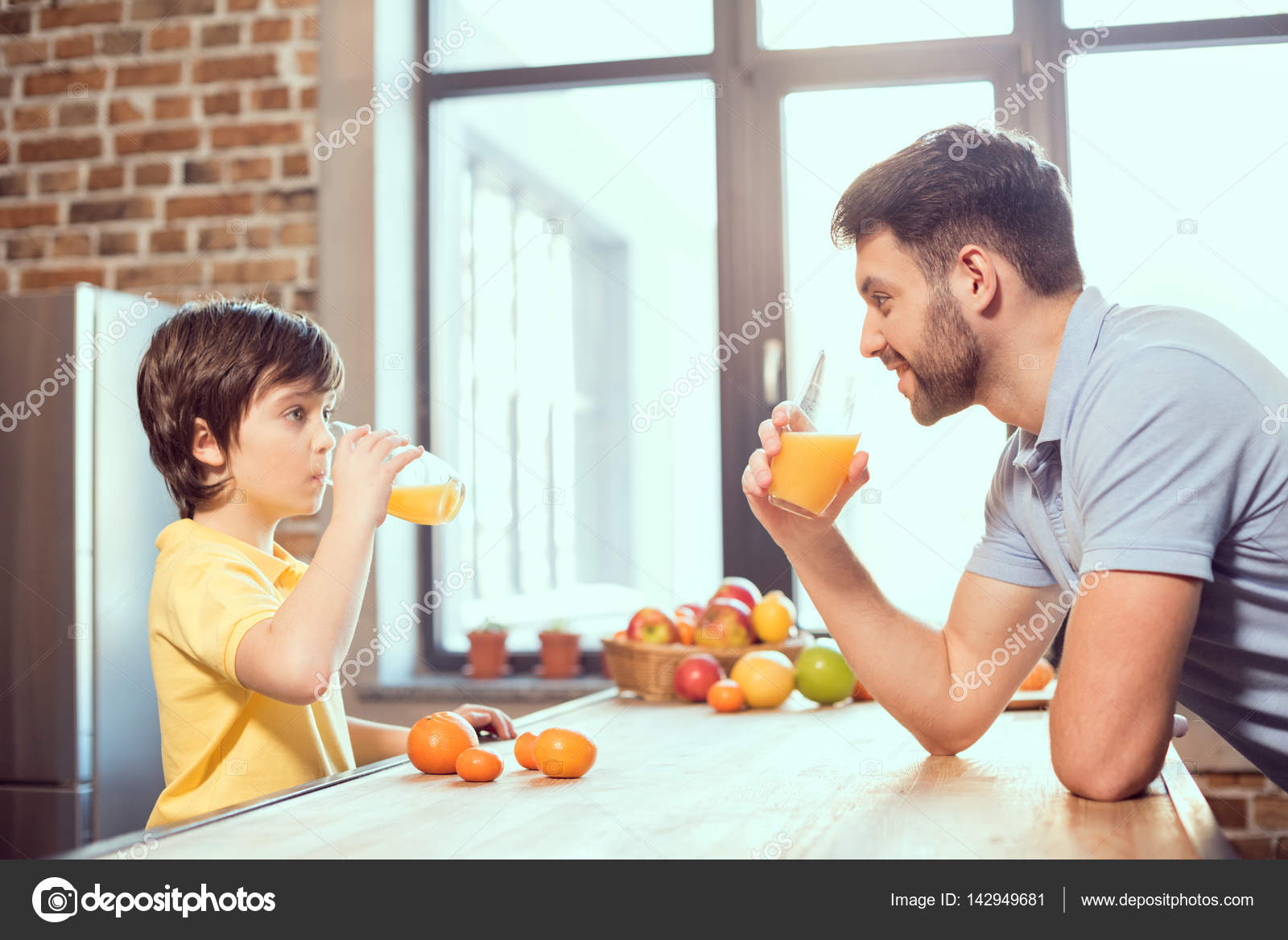Father and son drinking juice — Stock Photo © NatashaFedorova 142949681