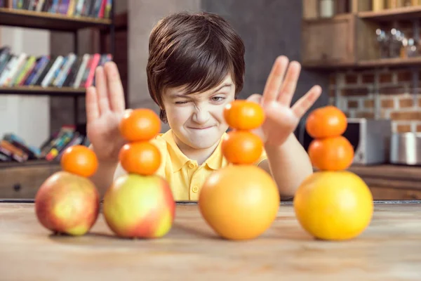 Мальчик играет с фруктами — стоковое фото