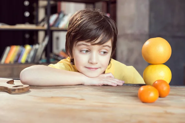 Chlapec hrající s ovocem — Stock fotografie