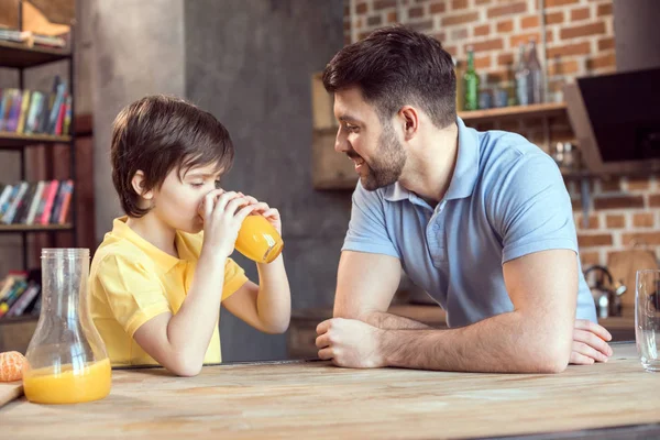 Vader en zoon drinken sap. — Stockfoto