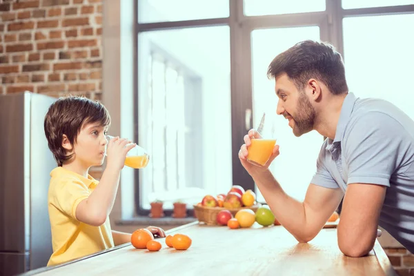 Padre e hijo bebiendo jugo — Foto de Stock