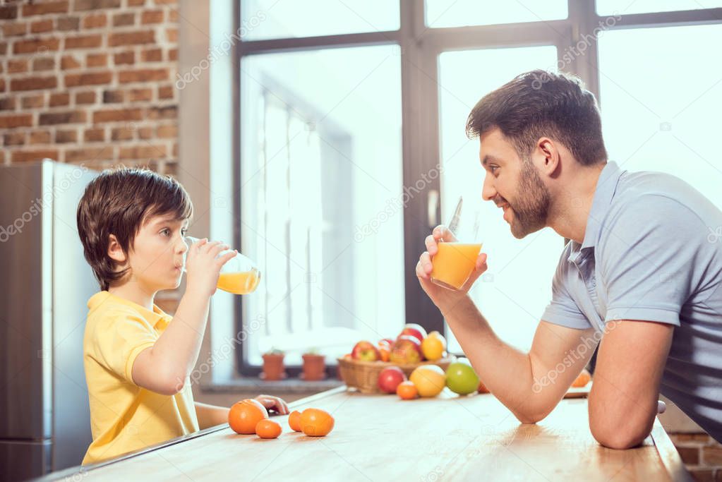 Father and son drinking juice