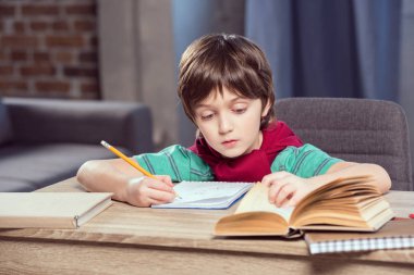Çocuk ödevini yapıyor.