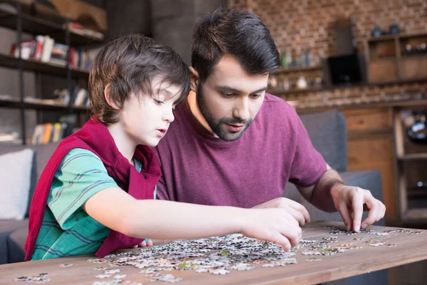 Отец и сын бледнеют с головоломками — стоковое фото