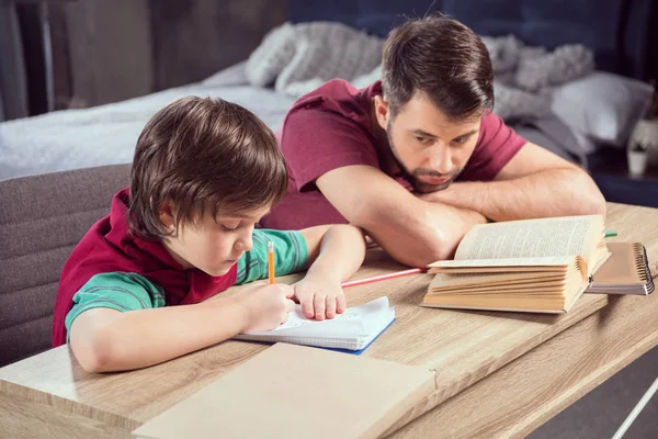 Vader helpt zoon huiswerk te maken — Stockfoto