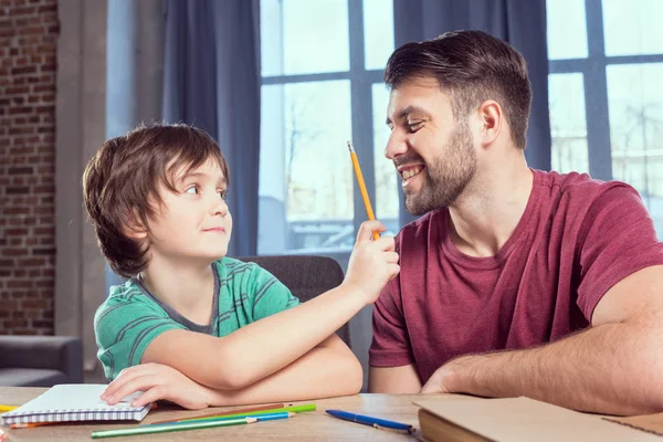 Apa segít a fiának házi feladatot csinálni. — Stock Fotó