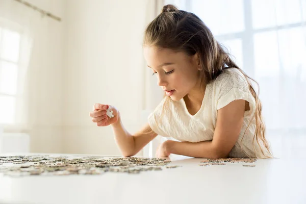Dívka si hraje s puzzle — Stock fotografie