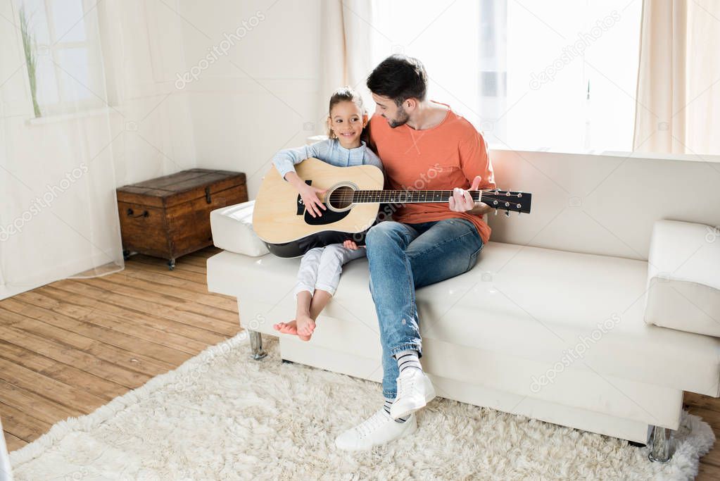 Father and daughter playing guitar