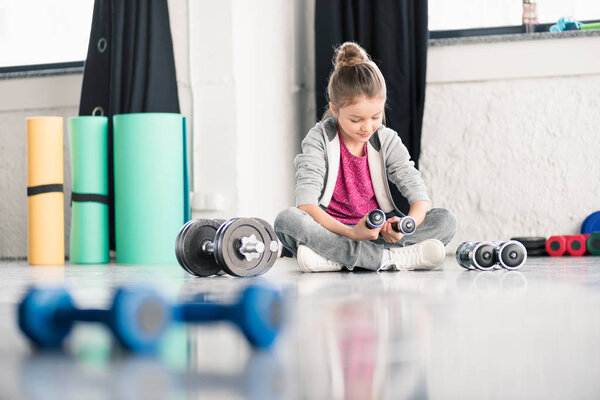 Girl exercising with dumbbells 