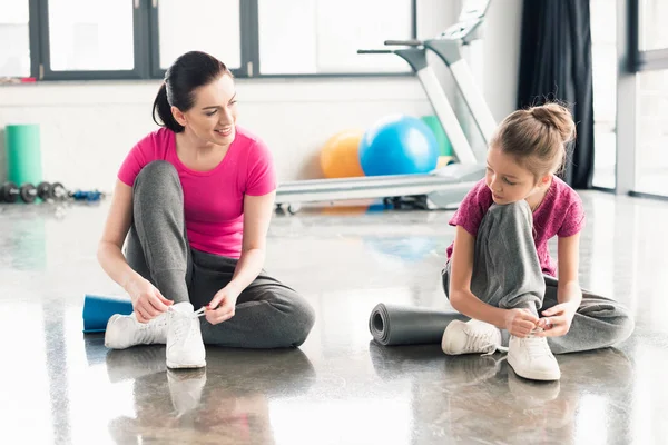 Mother and daughter tying shoelaces — Stock Photo, Image