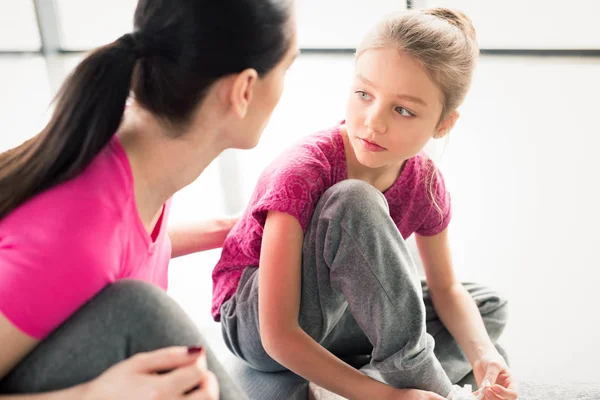 Mother and daughter sitting in gym — Stock Photo, Image